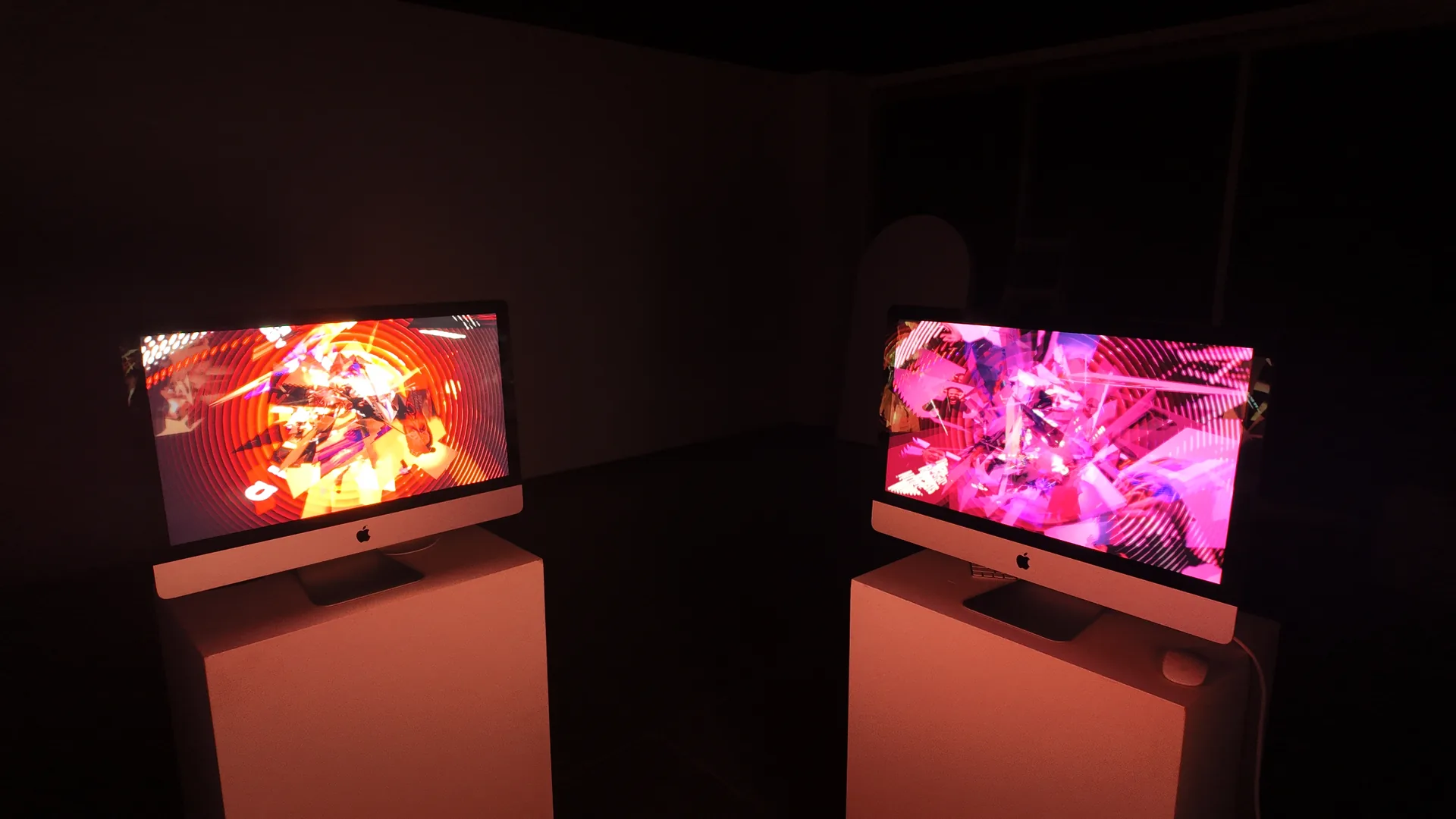 Earlier Ω installation view with two screens showing orange and pink compositions. Artwork by Jeanyoon Choi.