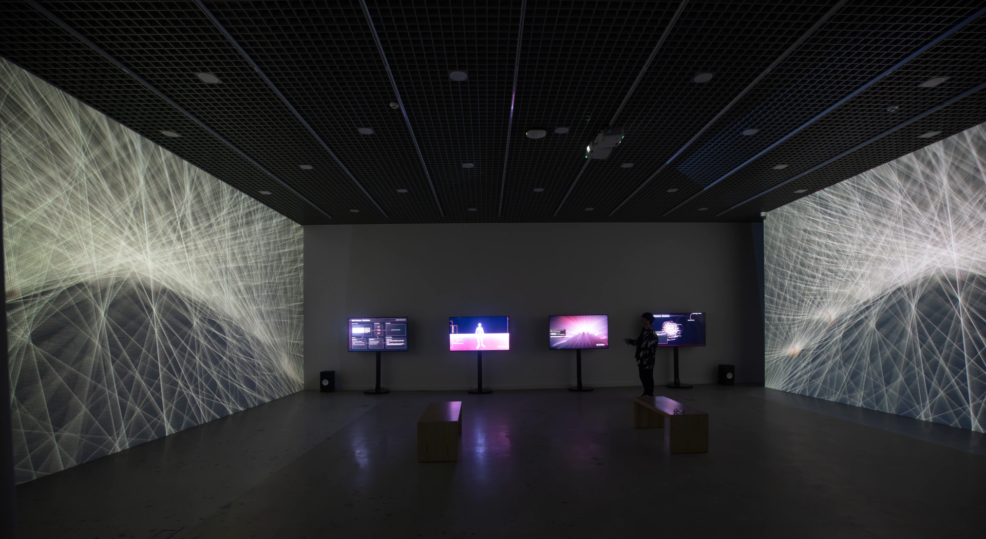 SoTA: wide view of the installation with projected abstract lines and central screens. Artwork by Jeanyoon Choi, Euan Kang, SeJoon Park, Minhyeok Seo, Prof. Yiyun Kang.